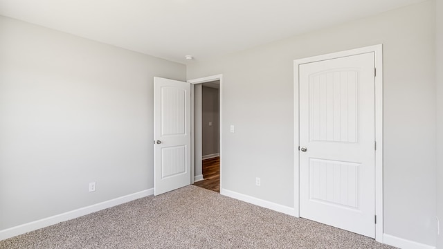 unfurnished bedroom featuring baseboards and carpet flooring