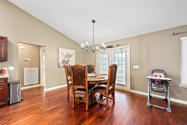 dining space with a notable chandelier, baseboards, dark wood-style flooring, vaulted ceiling, and visible vents