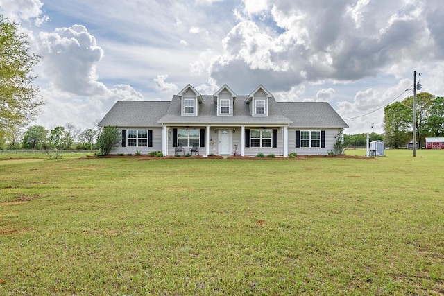 cape cod home featuring a shingled roof, a front lawn, and covered porch