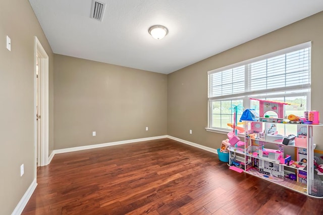 playroom featuring wood finished floors, baseboards, and visible vents