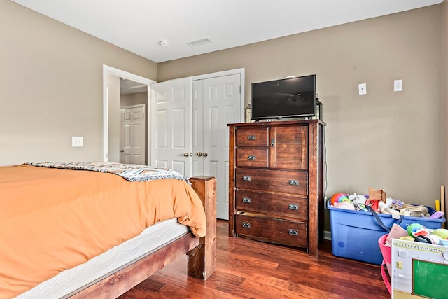 bedroom with visible vents, a closet, and wood finished floors