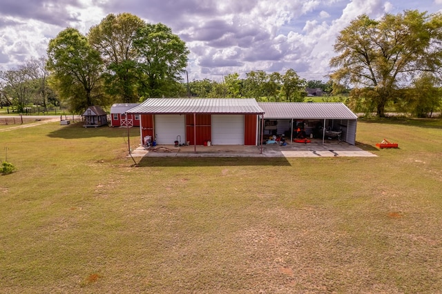 rear view of property featuring an outbuilding, metal roof, and a lawn