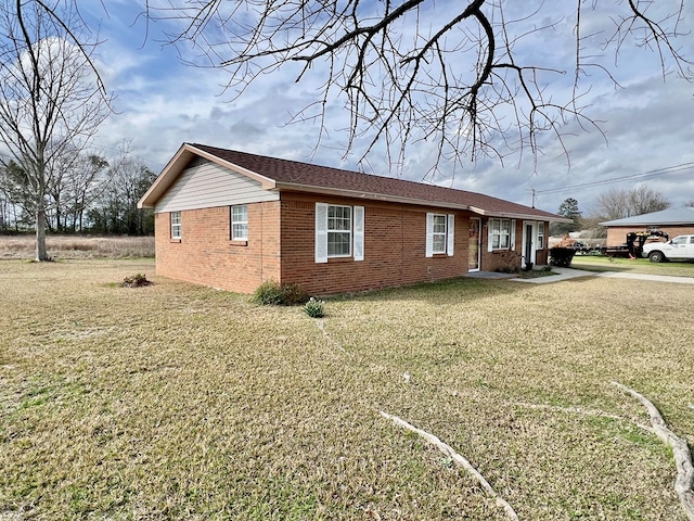 view of home's exterior with a yard and brick siding