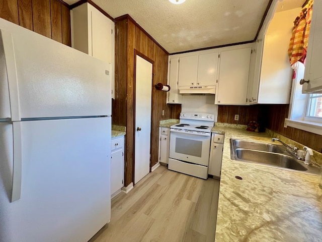 kitchen with white appliances, light countertops, under cabinet range hood, and a sink