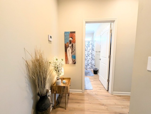 hall with baseboards and light wood-style flooring