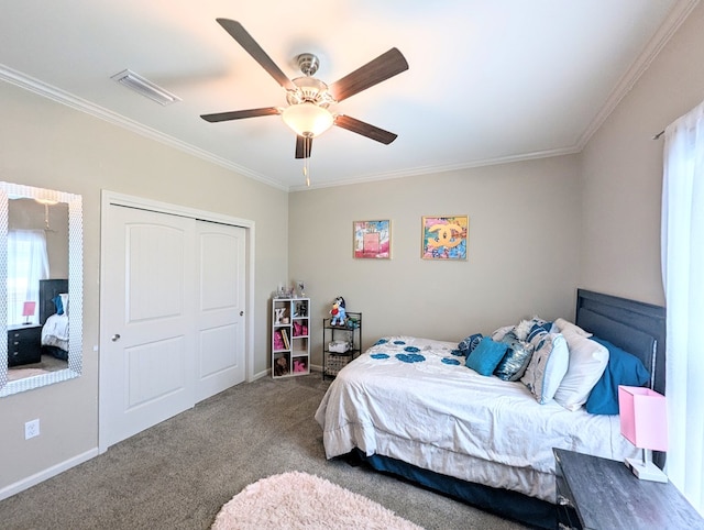 carpeted bedroom with a closet, ornamental molding, ceiling fan, baseboards, and visible vents