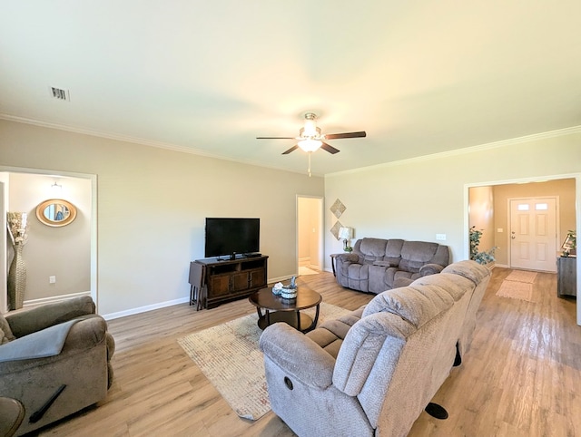 living area with crown molding, light wood-style floors, visible vents, baseboards, and a ceiling fan