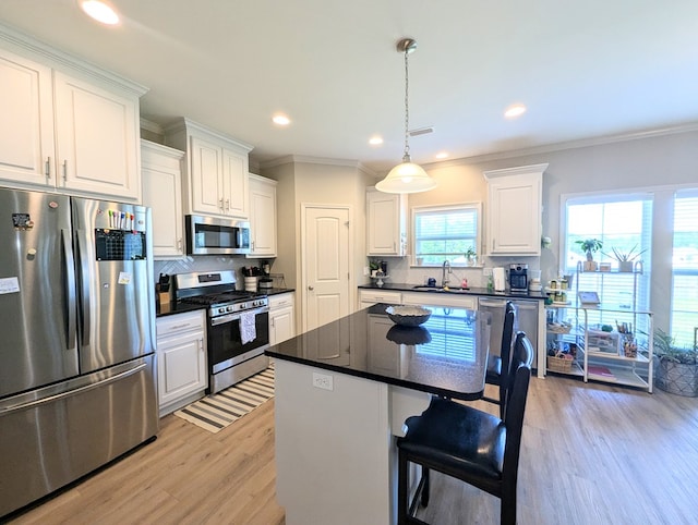 kitchen featuring tasteful backsplash, dark countertops, stainless steel appliances, and light wood-type flooring