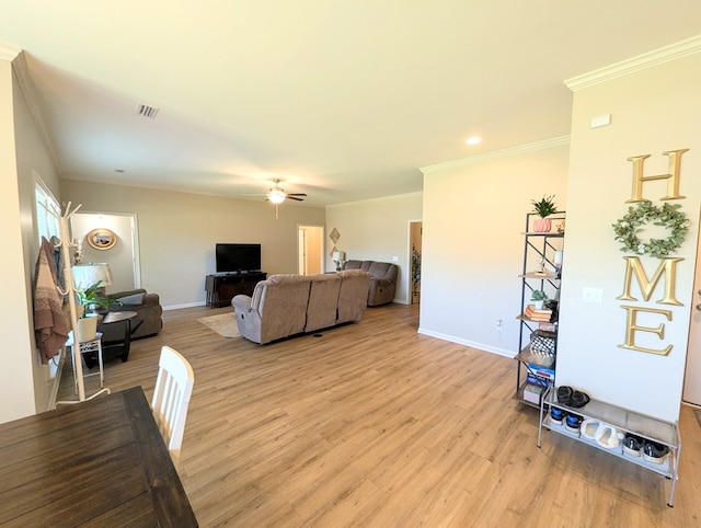 living room with baseboards, a ceiling fan, crown molding, and light wood finished floors