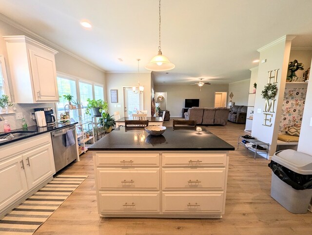 kitchen featuring dark countertops, dishwasher, ornamental molding, and white cabinets