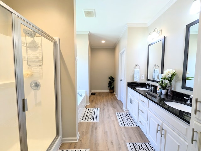 bathroom featuring ornamental molding, a sink, wood finished floors, and visible vents