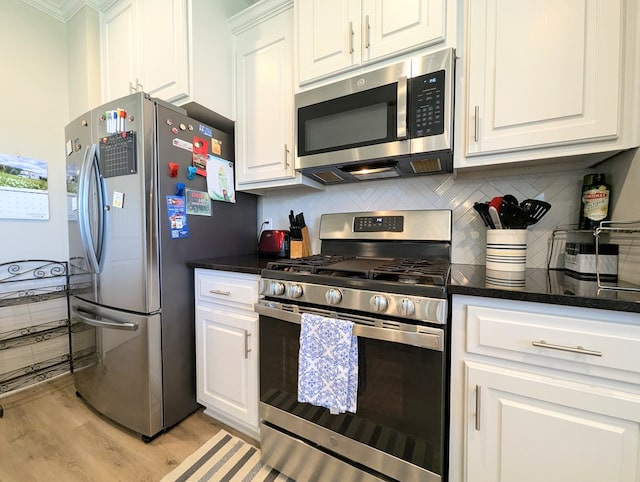 kitchen featuring white cabinetry, backsplash, light wood-style floors, and appliances with stainless steel finishes