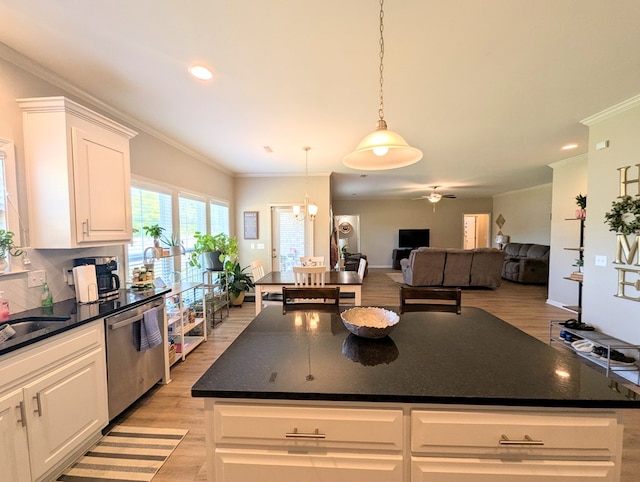 kitchen featuring stainless steel dishwasher, dark countertops, white cabinetry, light wood-type flooring, and open floor plan