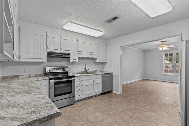 kitchen featuring appliances with stainless steel finishes, ornamental molding, a textured ceiling, sink, and white cabinets