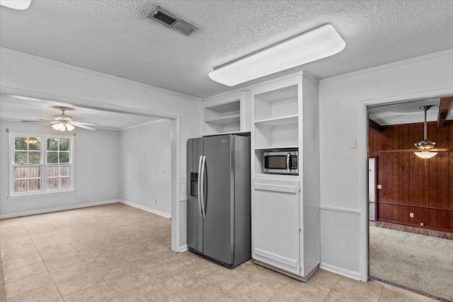 kitchen with ceiling fan, stainless steel appliances, a textured ceiling, and ornamental molding