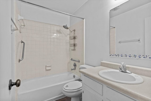 full bathroom featuring vanity, tiled shower / bath combo, and toilet