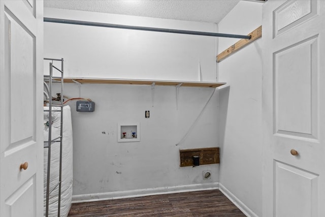 washroom with hookup for an electric dryer, dark hardwood / wood-style flooring, a textured ceiling, and hookup for a washing machine