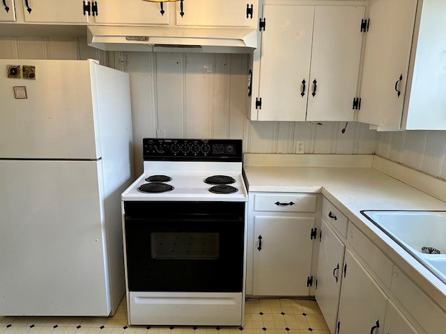 kitchen with freestanding refrigerator, range with electric cooktop, light floors, under cabinet range hood, and light countertops