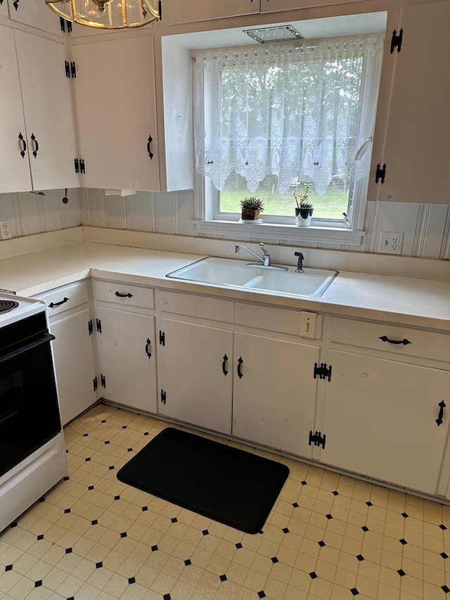 702 Highland St, Dothan, AL 36301 - kitchen featuring a sink, white range with electric stovetop, white cabinetry, light flooring, and light countertops