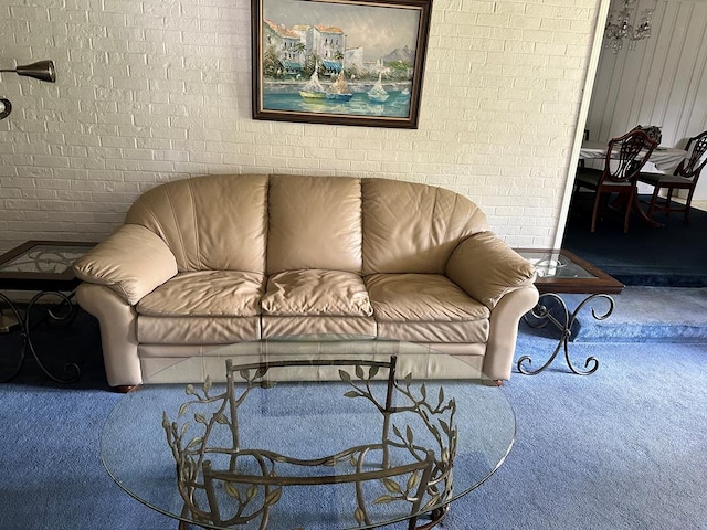 carpeted living room with brick wall