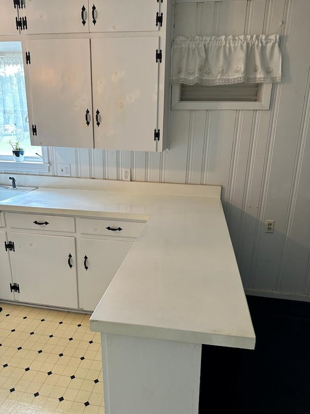 kitchen with white cabinets, tile patterned floors, light countertops, and a sink