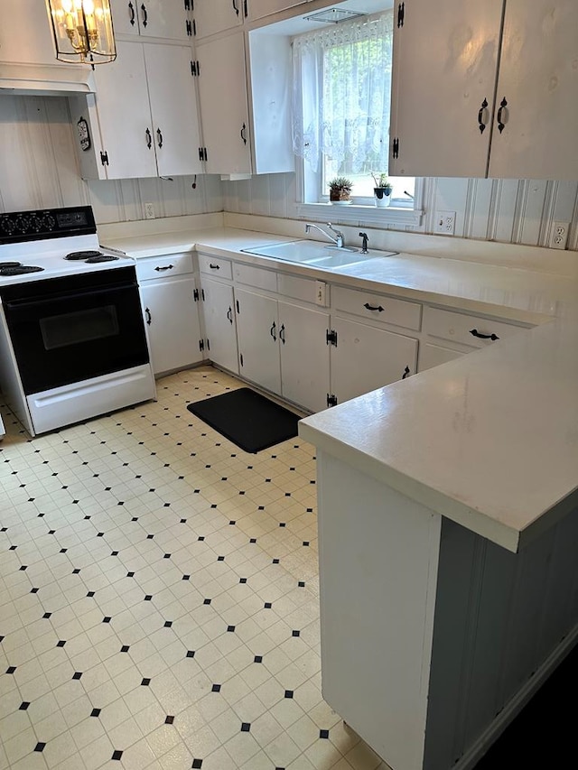 702 Highland St, Dothan, AL 36301 - kitchen featuring range with electric cooktop, light countertops, a sink, white cabinets, and light floors