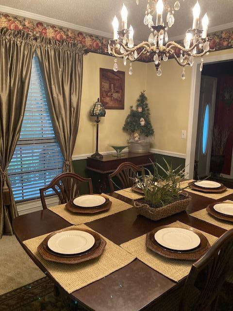 dining room featuring ornamental molding and an inviting chandelier