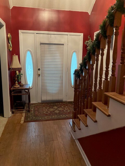 entrance foyer featuring hardwood / wood-style floors and crown molding