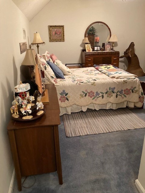 bedroom with carpet floors, vaulted ceiling, and a baseboard heating unit