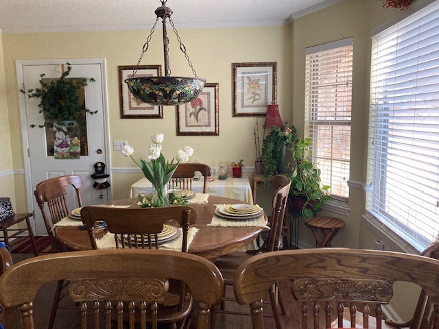 dining space with a wealth of natural light and ornamental molding