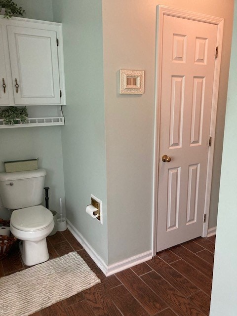 bathroom featuring baseboards, toilet, and wood finish floors