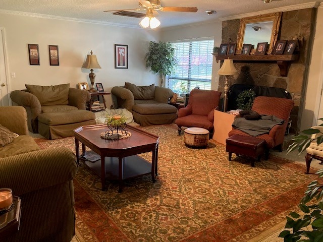 living area featuring ornamental molding, a fireplace, and ceiling fan