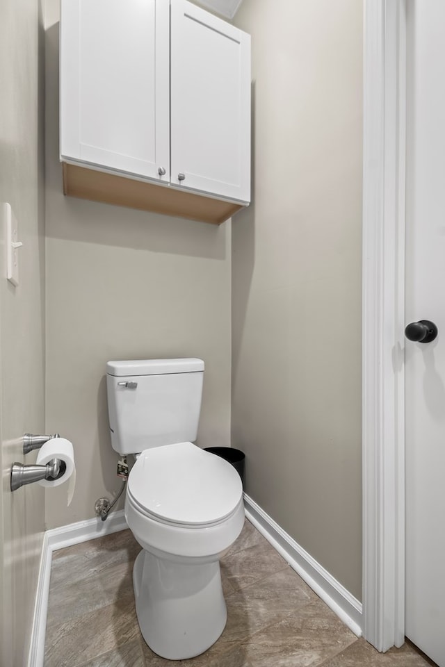 bathroom with baseboards and toilet