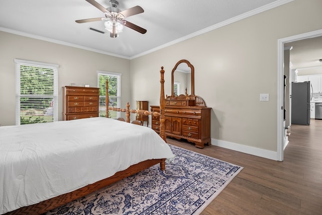bedroom with crown molding, wood finished floors, baseboards, visible vents, and freestanding refrigerator