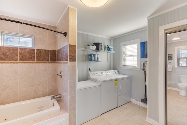 washroom featuring washing machine and dryer, crown molding, a healthy amount of sunlight, and light tile patterned flooring