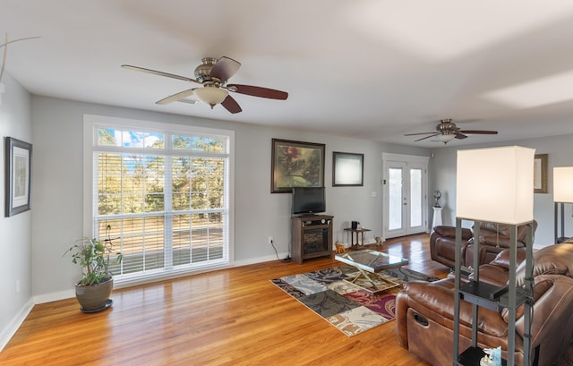 living room with french doors, light wood-type flooring, and ceiling fan