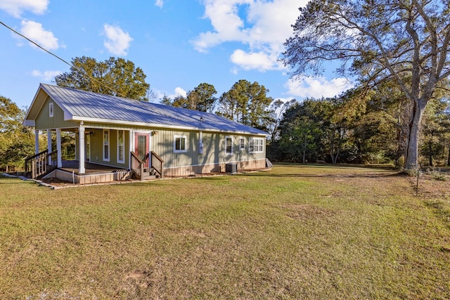 back of property with a lawn, cooling unit, and covered porch