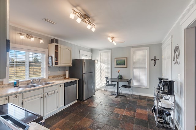 kitchen with crown molding, white cabinetry, sink, and appliances with stainless steel finishes