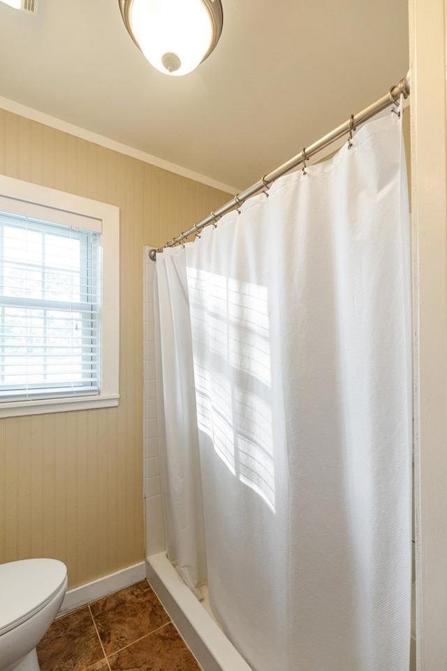 bathroom featuring tile patterned flooring, a shower with shower curtain, toilet, and crown molding