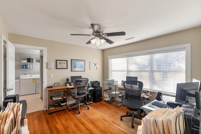 home office featuring ceiling fan, light wood-type flooring, and separate washer and dryer