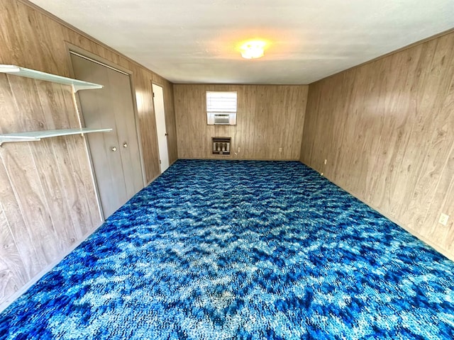 carpeted spare room featuring cooling unit and wood walls