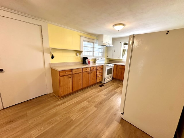 kitchen with light wood-style flooring, white appliances, light countertops, and brown cabinets