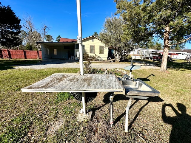 exterior space featuring an attached carport, driveway, and fence