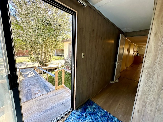 doorway with wooden walls and wood finished floors