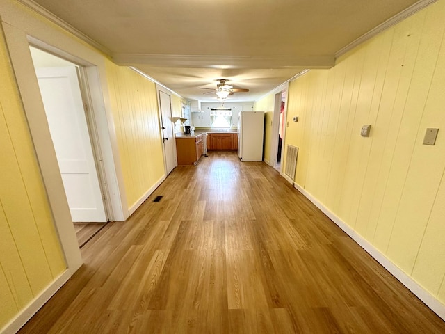 hall with visible vents, crown molding, and wood finished floors