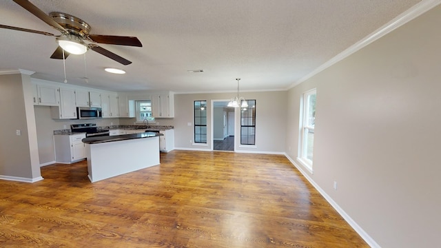 kitchen with white cabinets, appliances with stainless steel finishes, and ornamental molding