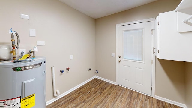 laundry room with cabinets, electric water heater, and wood-type flooring