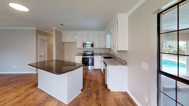 kitchen featuring dark stone countertops, white cabinetry, and stainless steel appliances