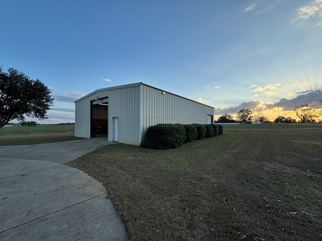 outdoor structure at dusk with a garage and a yard