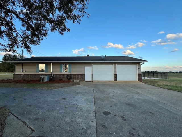 view of front of property featuring central air condition unit and a garage